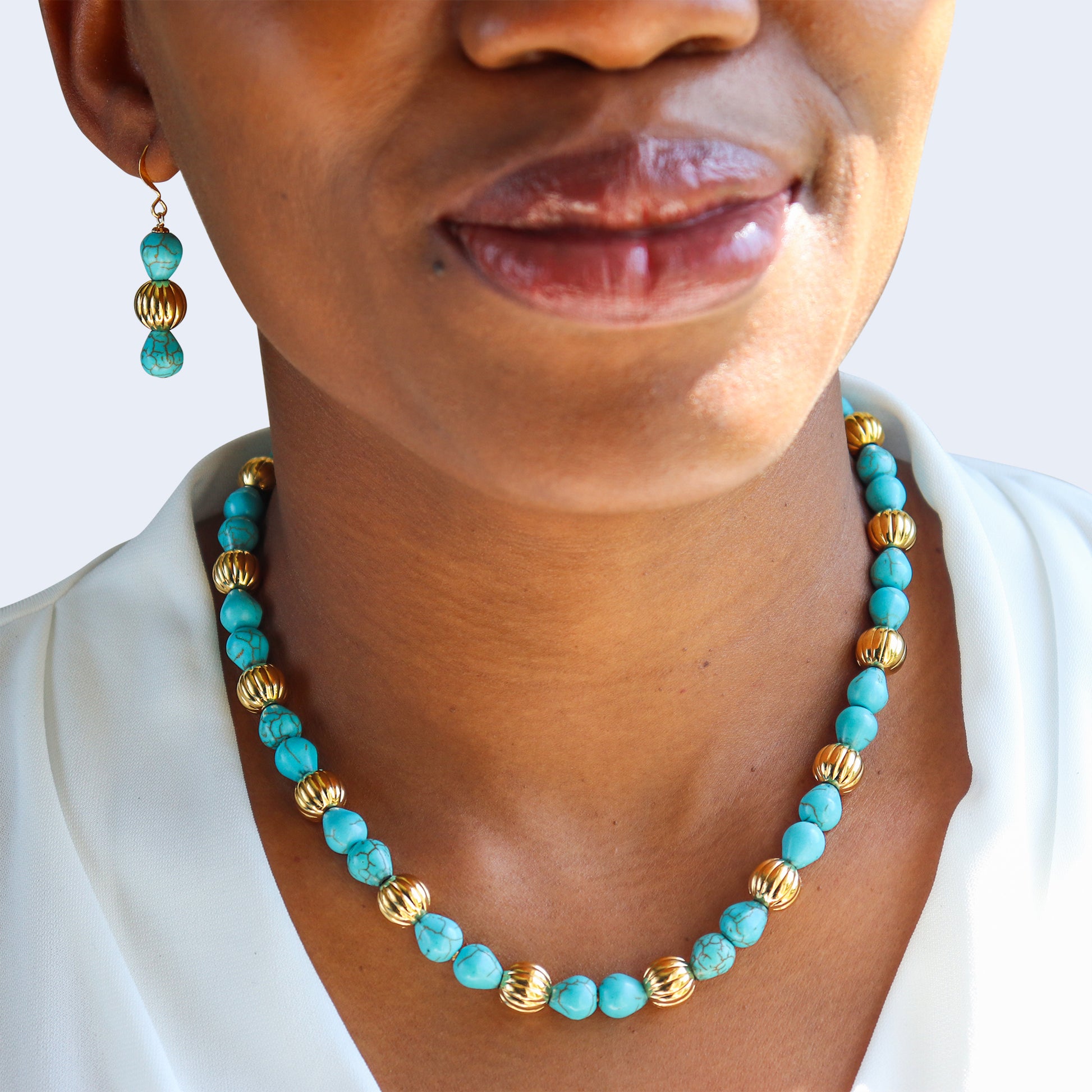 Statement gemstone earrings and necklace in gold tone.