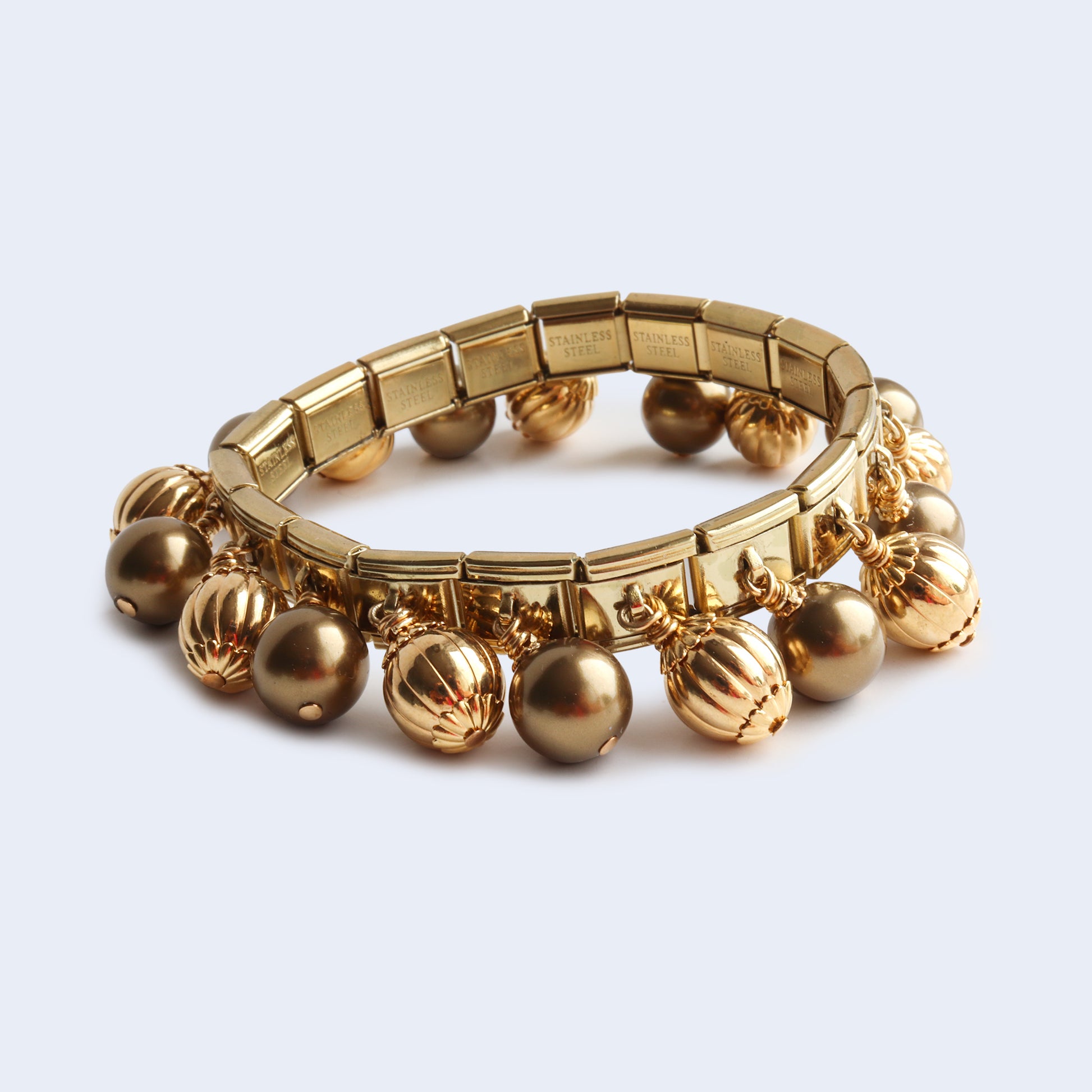 Gold tone bold bohemian style bracelet with pearls and metal beads.